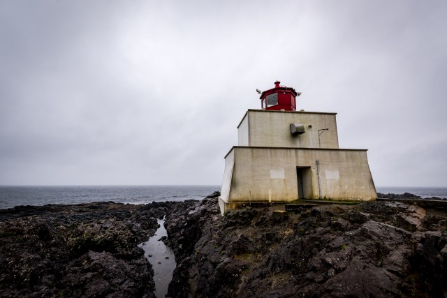 A lighthouse on a rocky coast, with an overcast sky